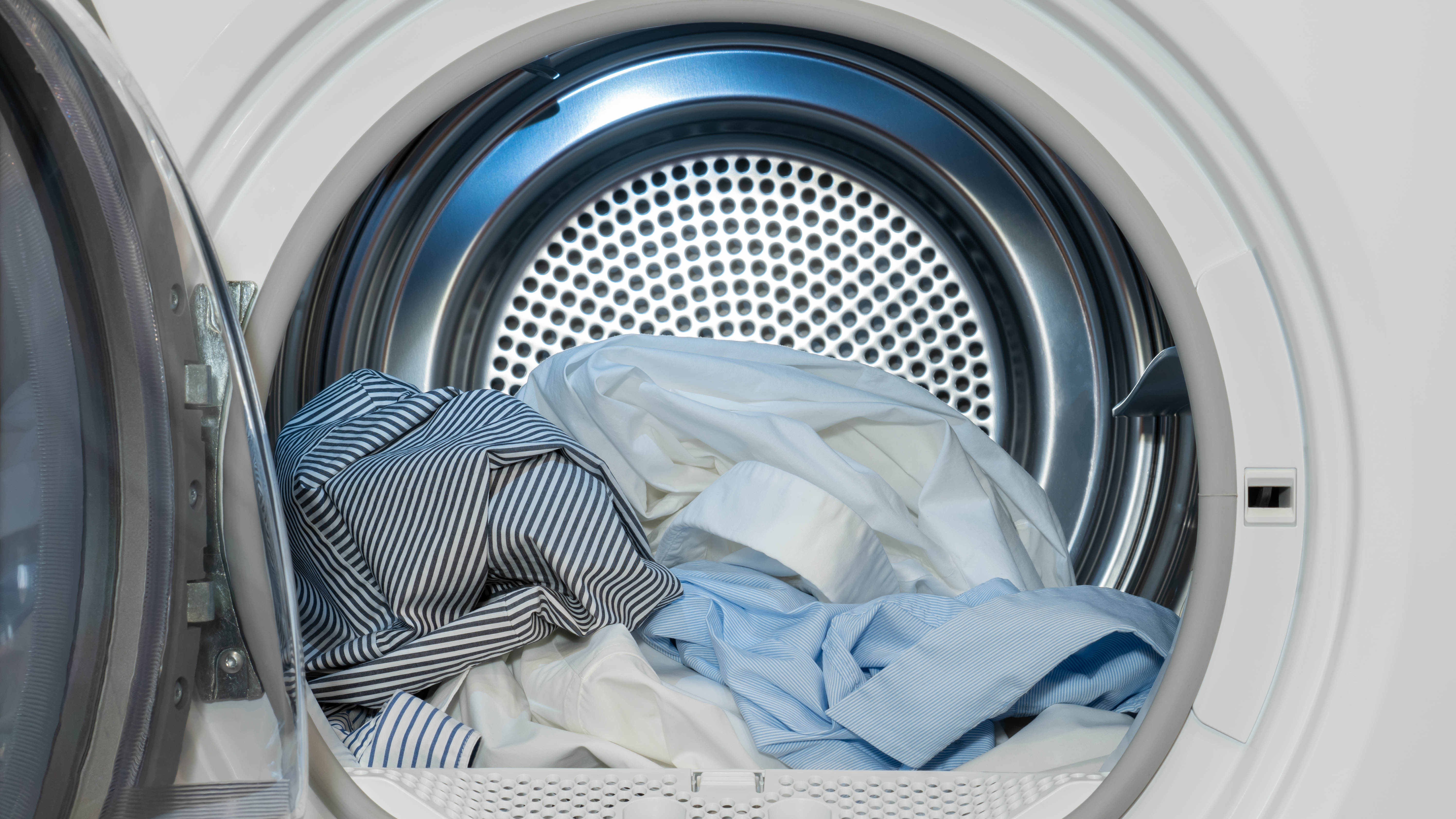 Un gros plan du tambour d'un sèche-linge avec des vêtements secs