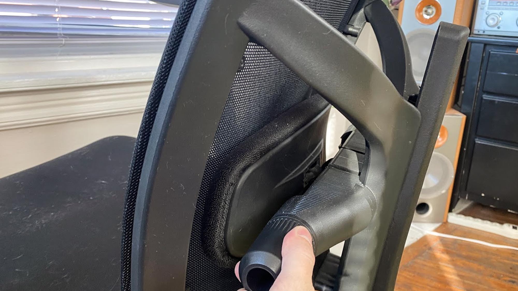 Une main ajustant le support lombaire sur une chaise de bureau