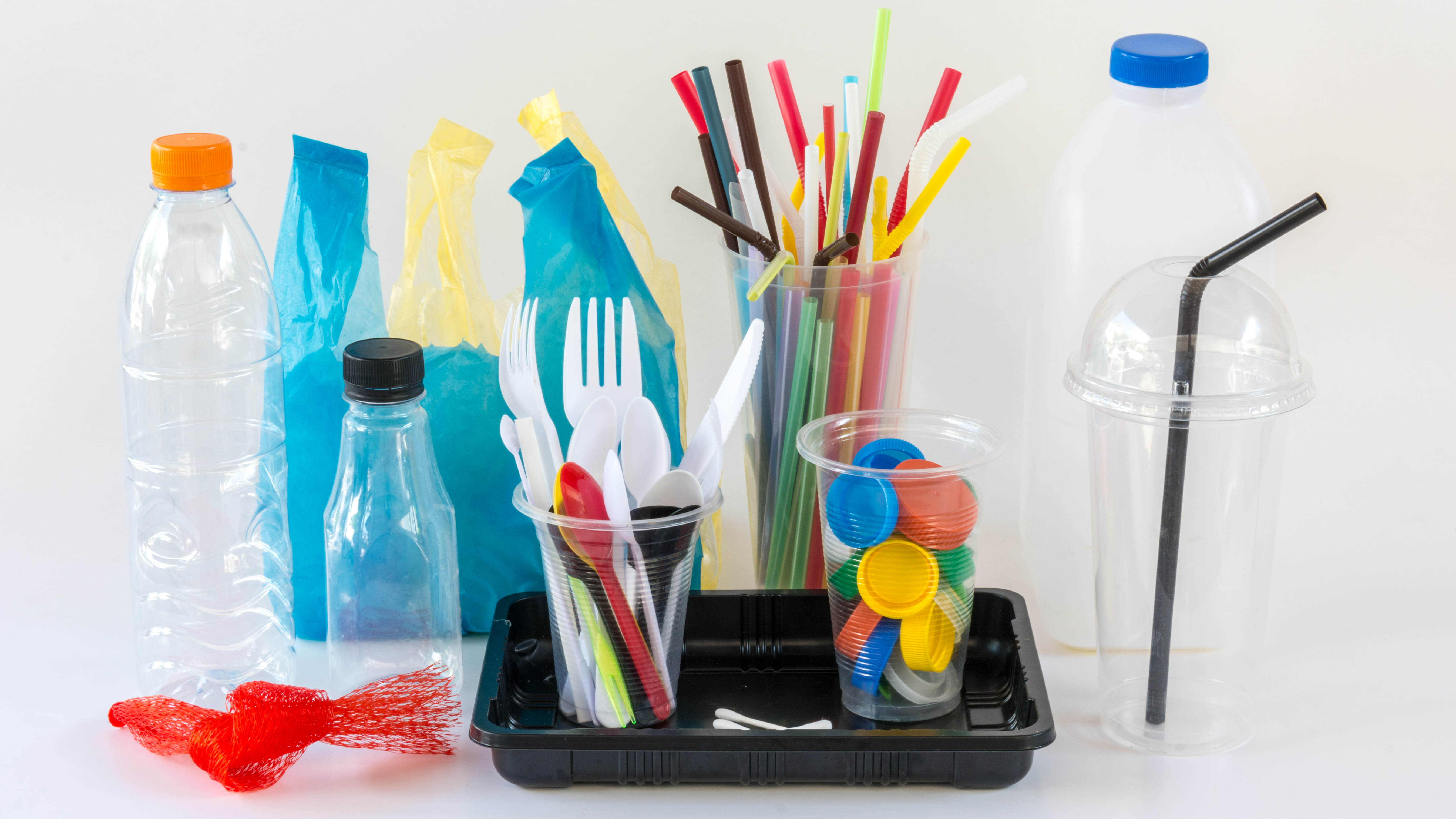 Pailles et ustensiles dans des bouteilles en plastique