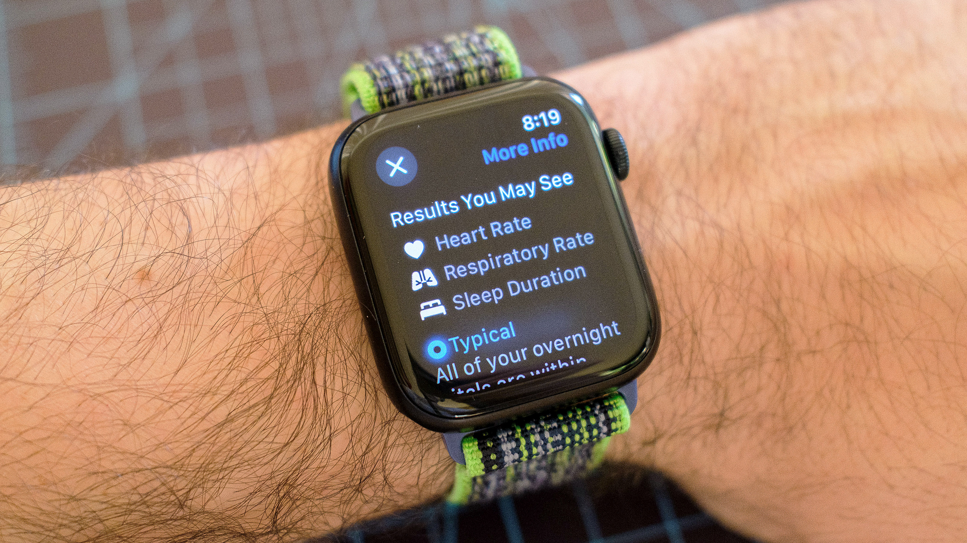 L'Apple Watch SE sur une sangle en tissu vert et gris montrant les détails de la nouvelle application Vitals