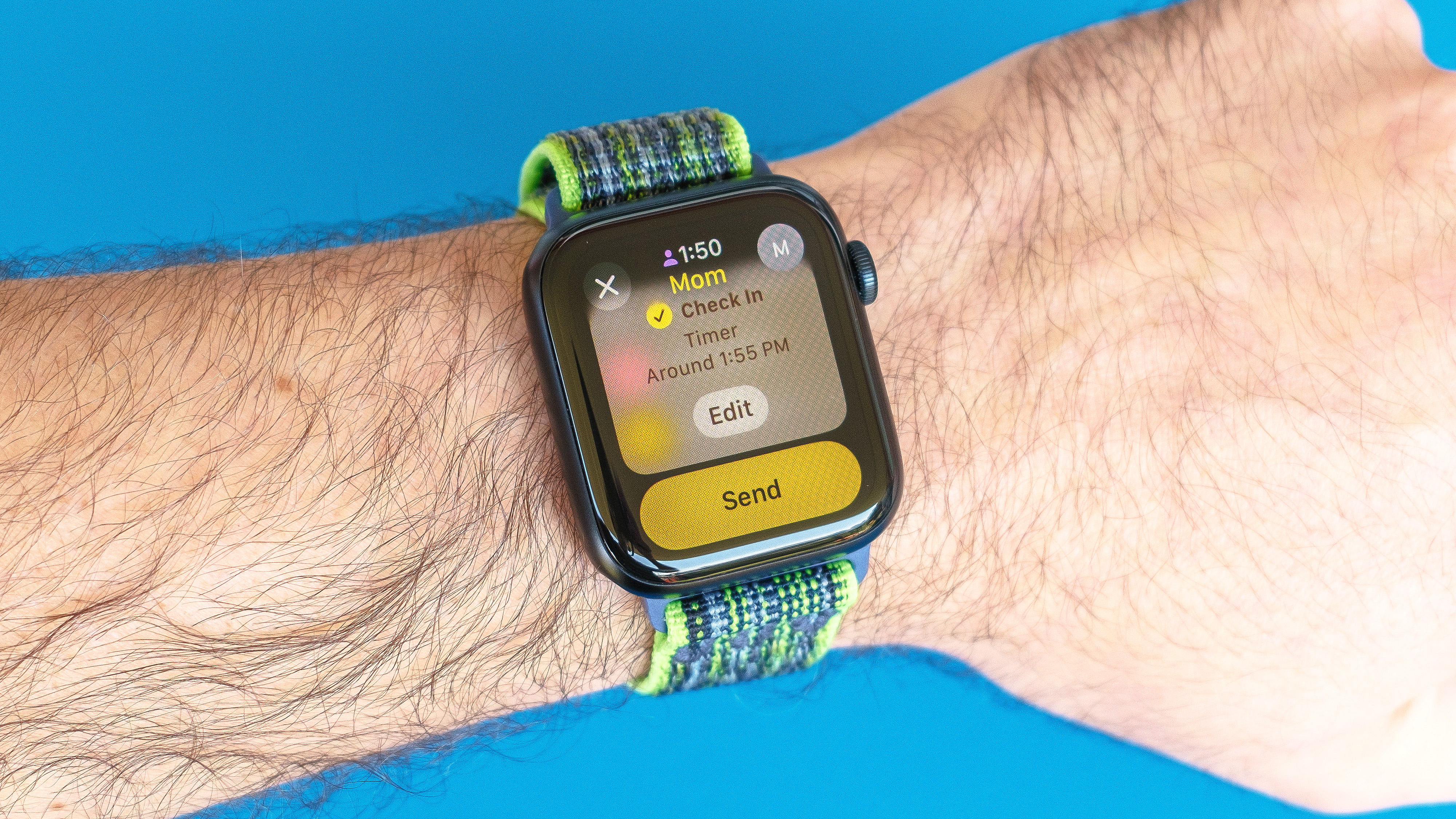 Détail photo d'une Apple Watch SE sur un fond bleu vif montrant les étapes à configurer et envoyer une notification d'enregistrement dans Watchos 11