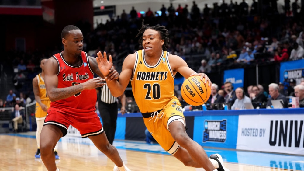Le TJ Madlock de l'Alabama State Hornets dribble le ballon devant le Daemar Kelly de Saint Francis Red Flash à March Madness 2025