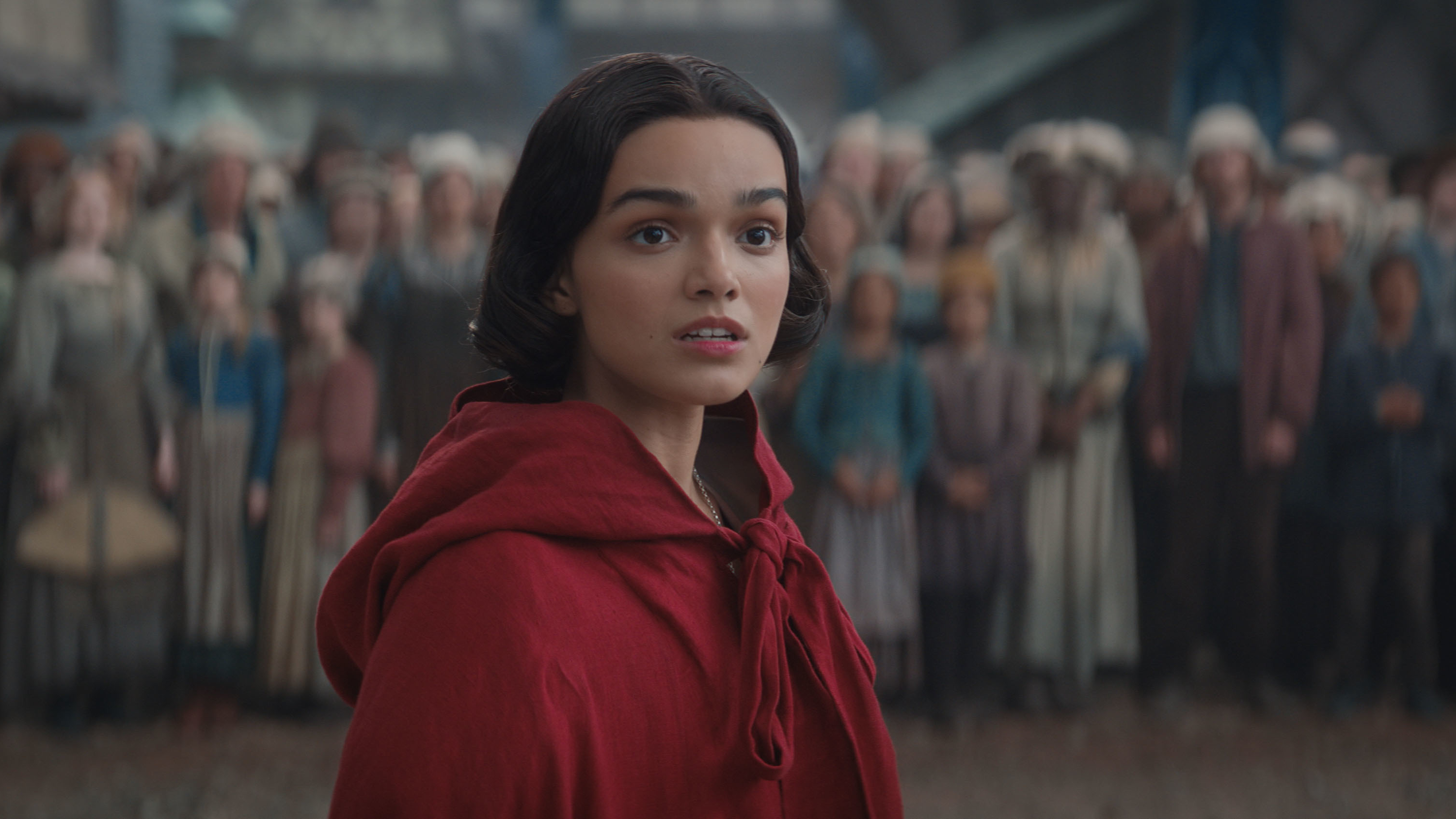 Blanche-Neige (Rachel Zegler) portant une manteau rouge dans une scène de l'action en direct de Disney "Blanc comme neige" remake