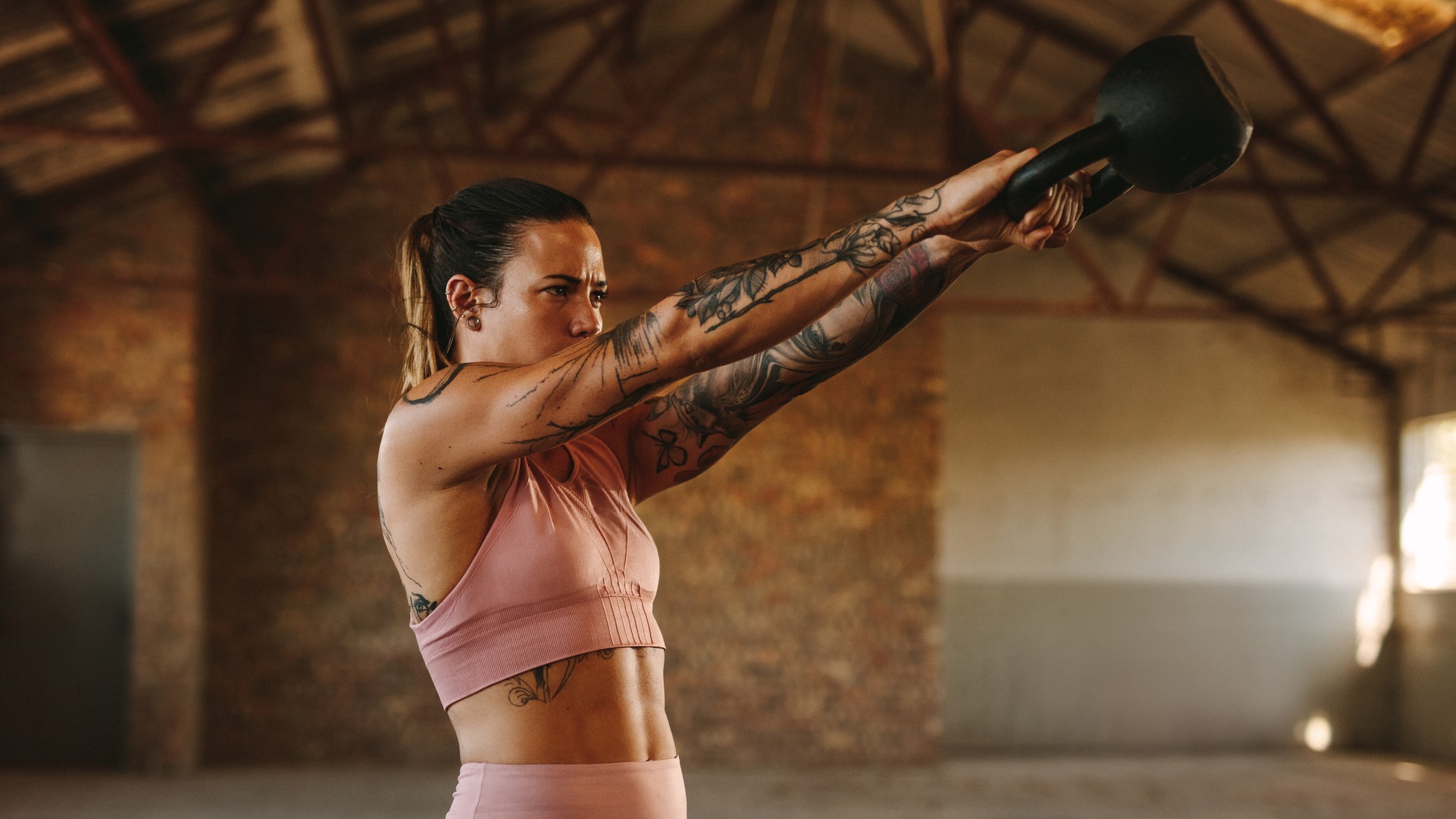 Une photo d'une femme faisant un swing de kettlebell