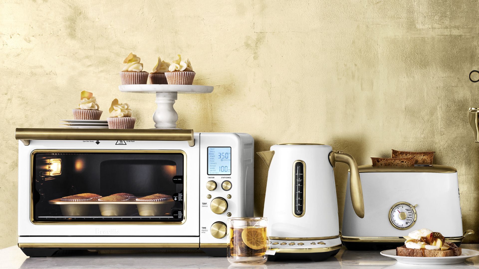Les appareils électroménagers de Breville's Brass Accent Kitchen se gèrent sur fond en laiton