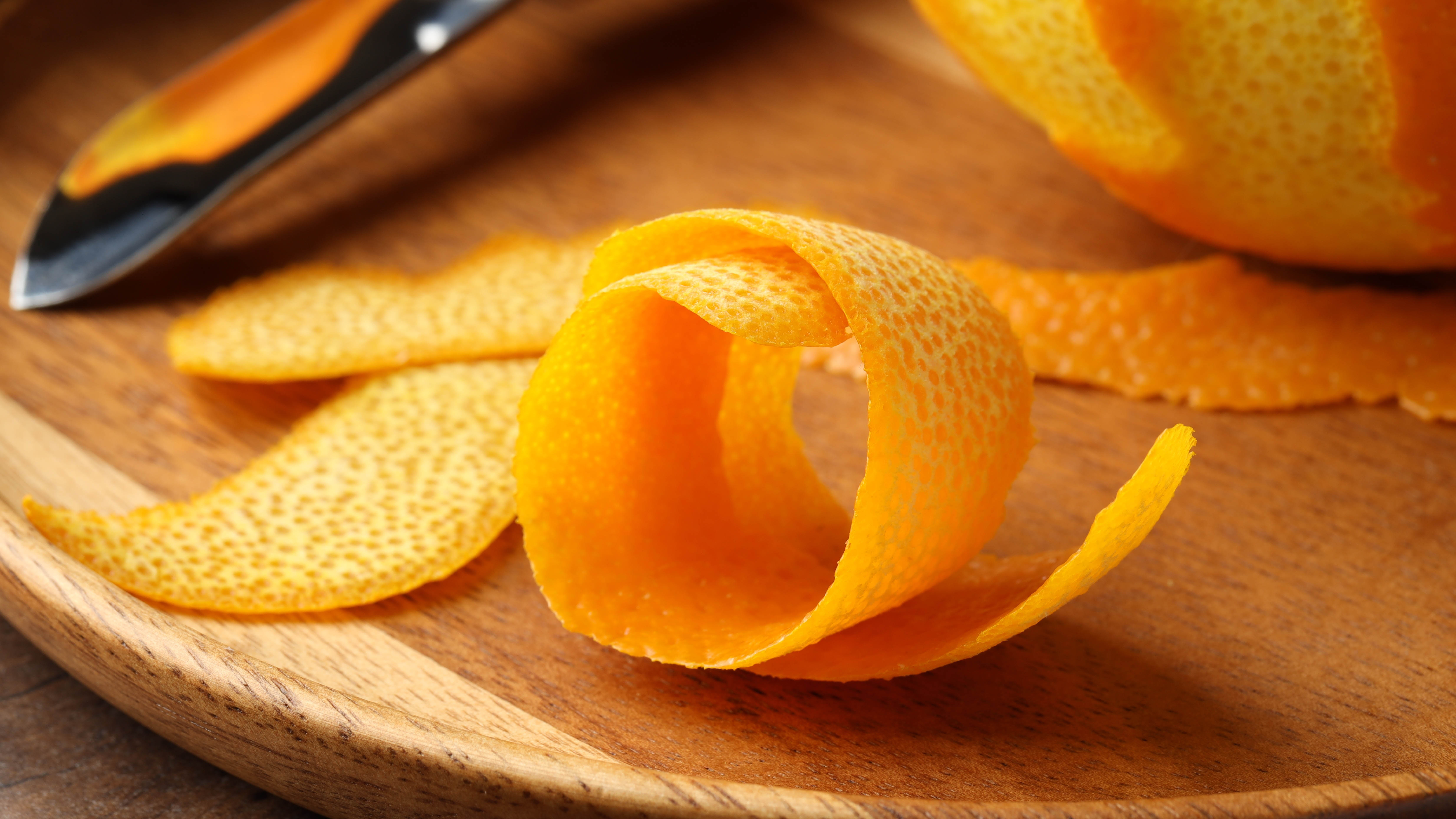 Orange Pels sur la planche à découper en bois