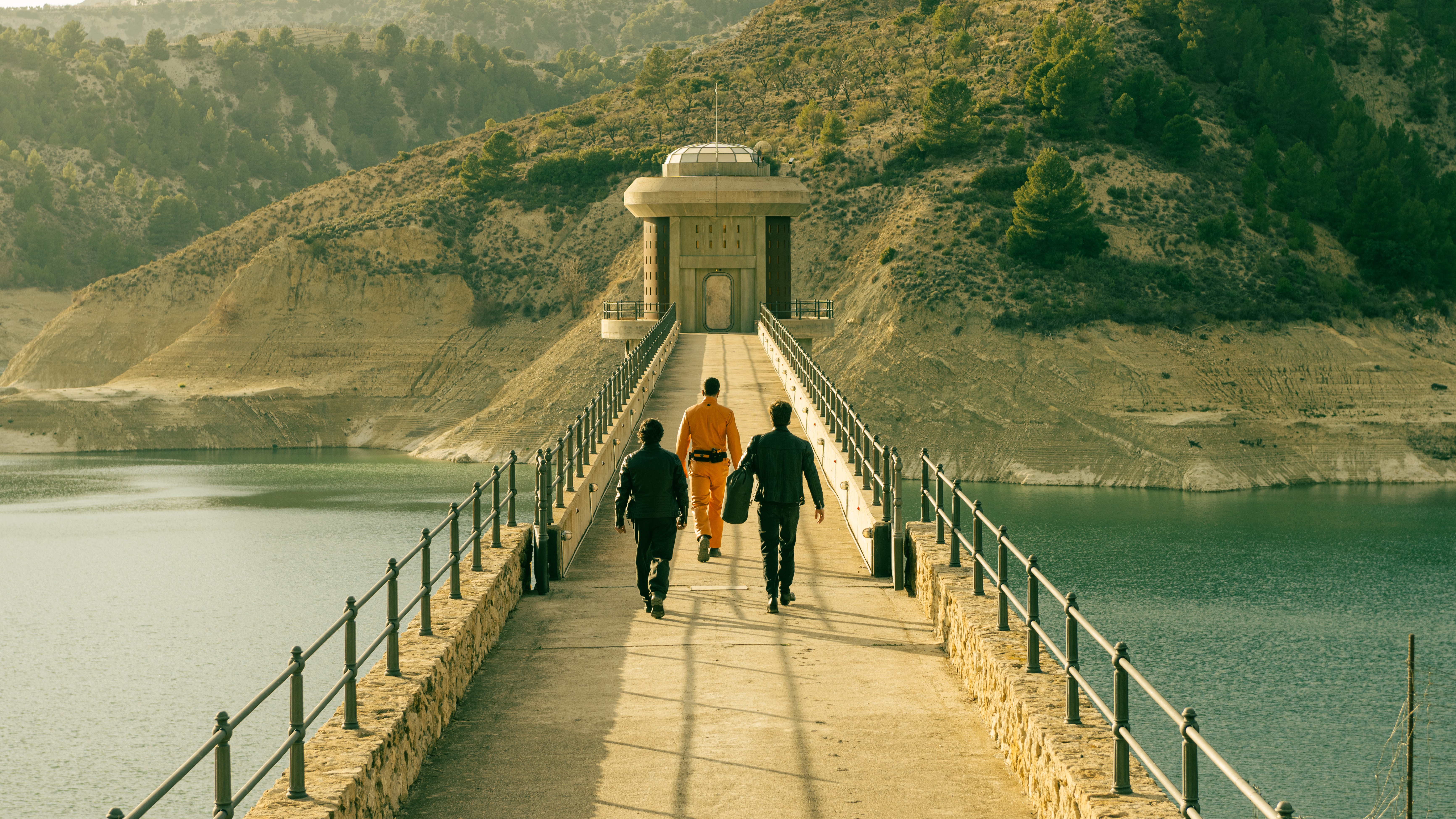 Une scène de Netflix "Bunker des milliardaires" Avec trois chiffres (face à la caméra) marchant sur un pont