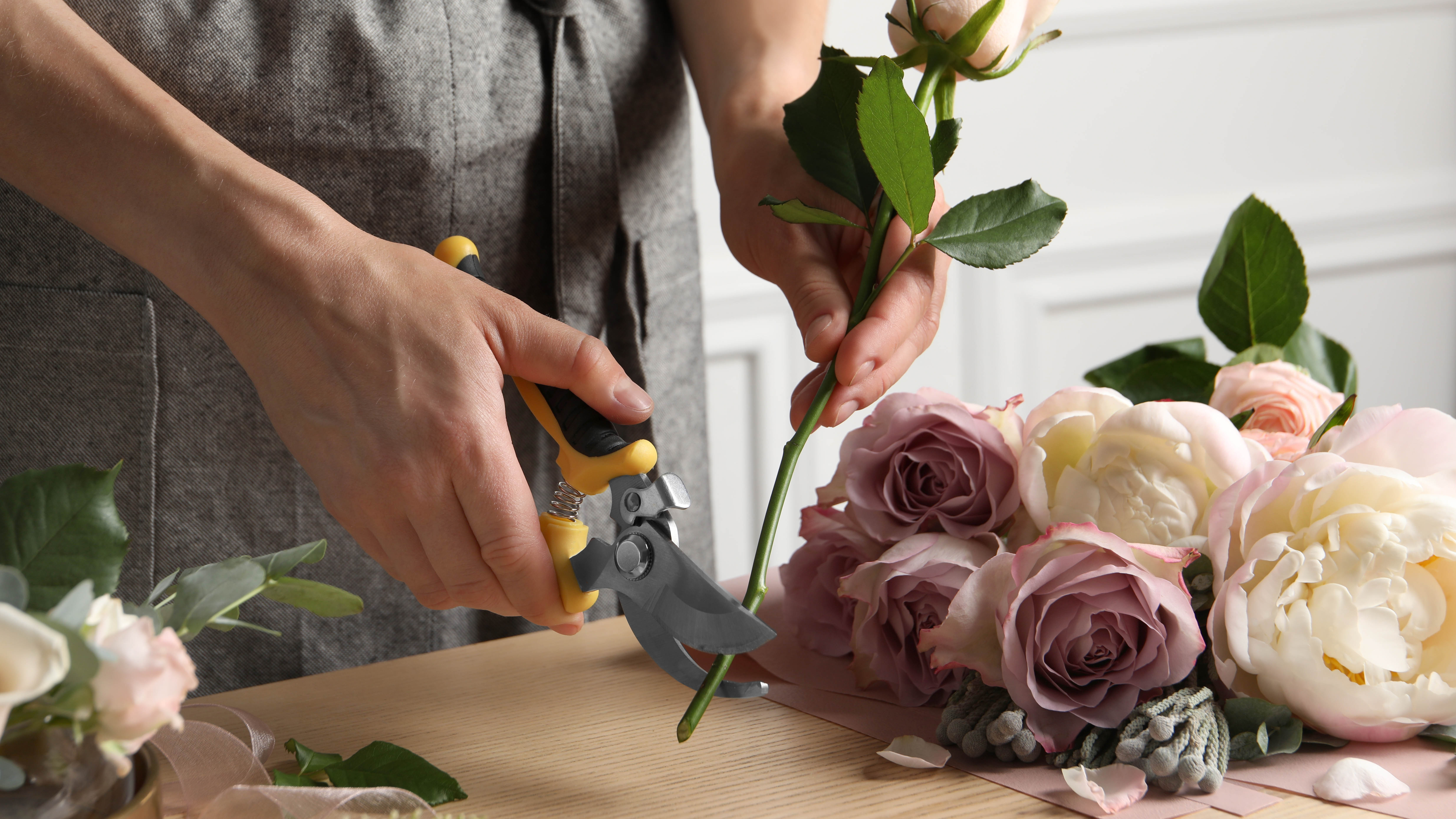 Une seule rose étant garnie d'une paire de fûts sur un comptoir de cuisine à côté d'un bouquet de roses