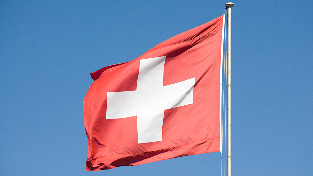 Drapeau suisse volant, avec un ciel bleu clair en arrière-plan