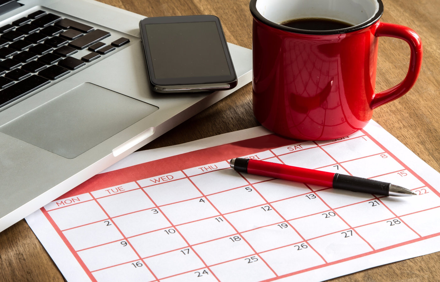 Calendrier à côté de l'ordinateur portable et de la tasse de café