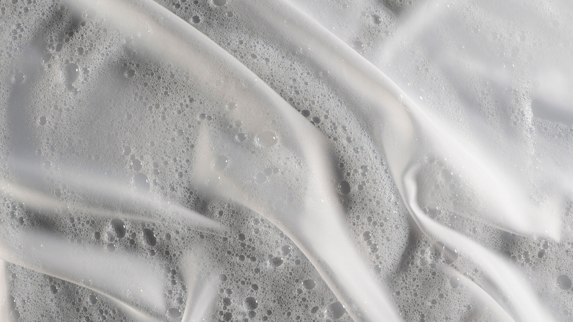 Bubbles savonneux sur un tissu de literie en soie blanche