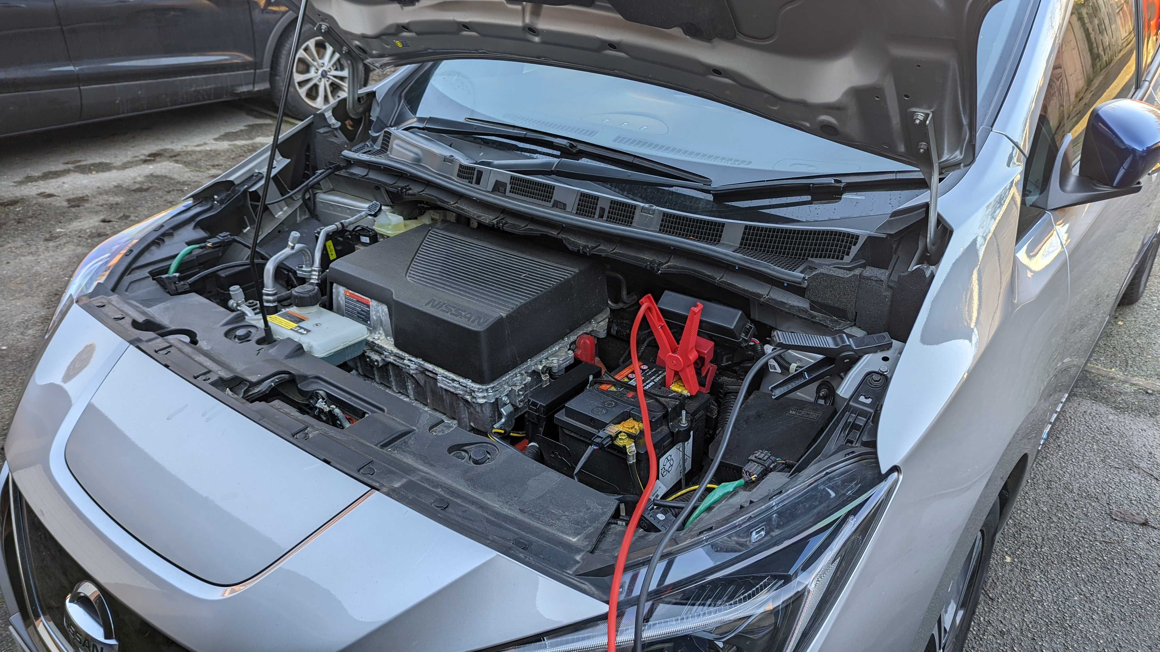 Nissan Leaf avec des câbles de cavalier connectés à la batterie 12V