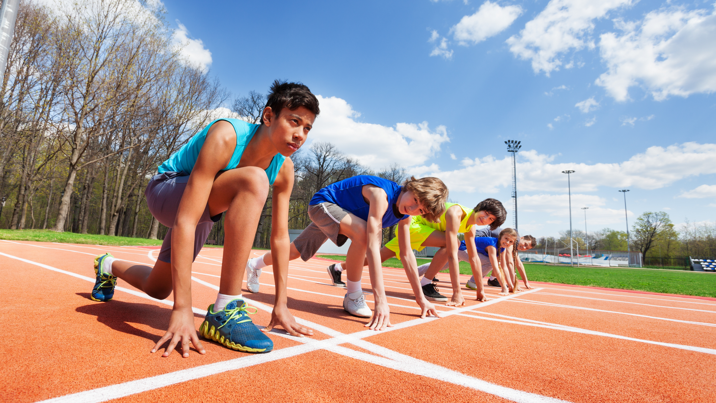 Kids s'aligne sur la ligne de départ d'une piste en cours d'exécution