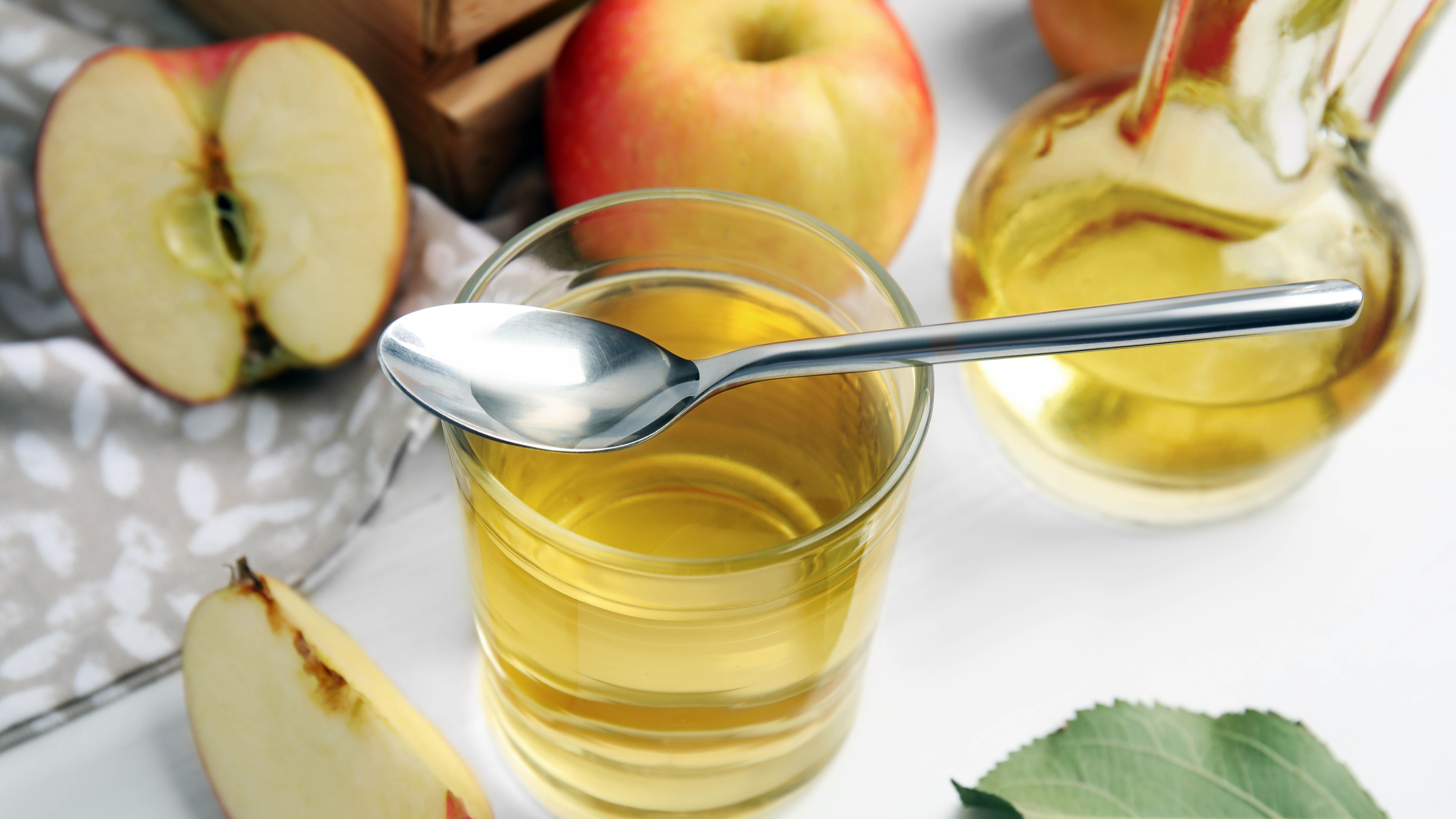 Verre de vinaigre de cidre de pomme avec des pommes