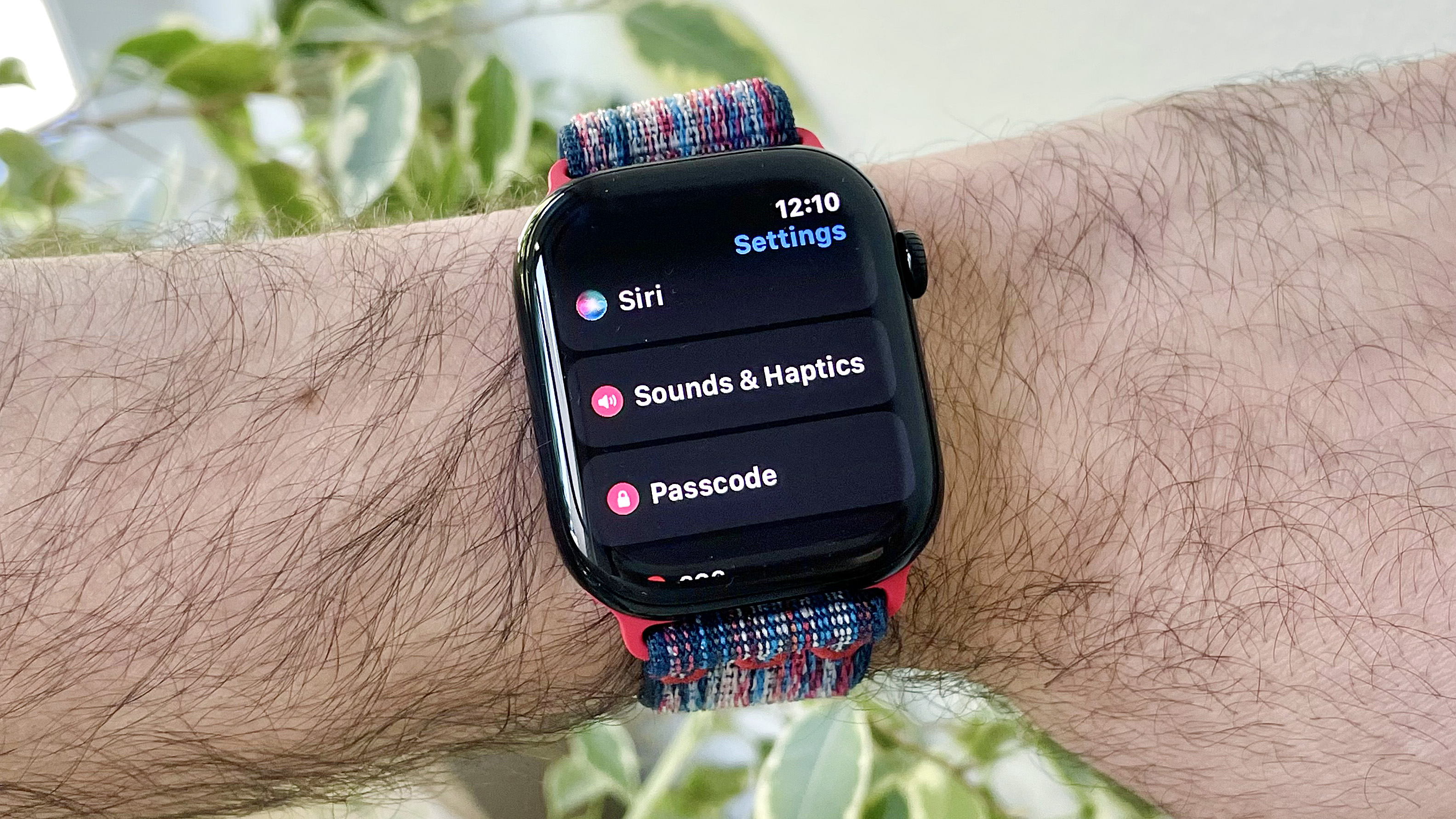 Gros plan du poignet d'un utilisateur portant l'Apple Watch Series 10 exécutant le dernier logiciel WatchOs 26. L'écran affiche le nouveau réglage des ajustements audio automatiques