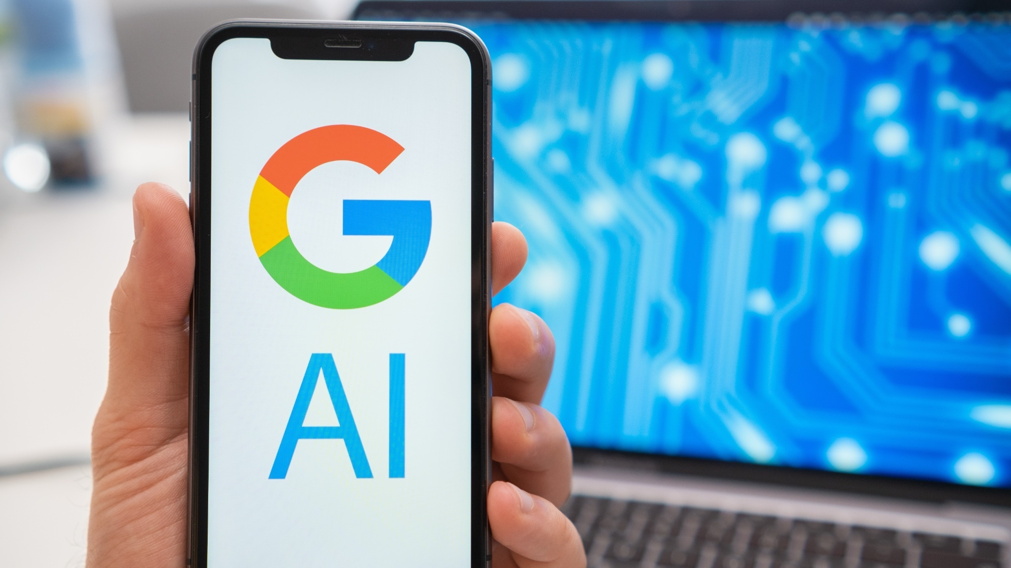 Google AI sur téléphone avec ordinateur portable en arrière-plan