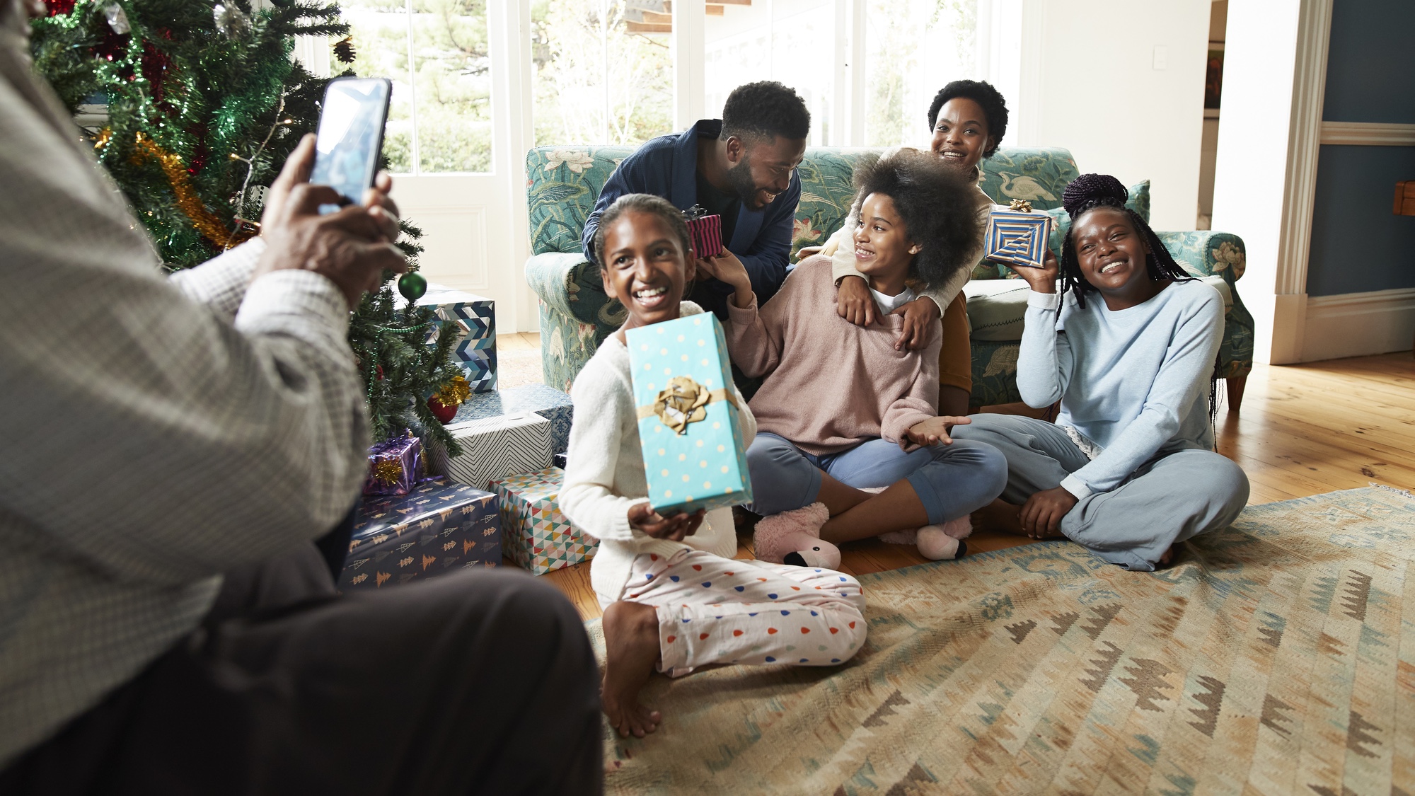Cadeaux d'ouverture de famille à Noël en prenant une photo de groupe