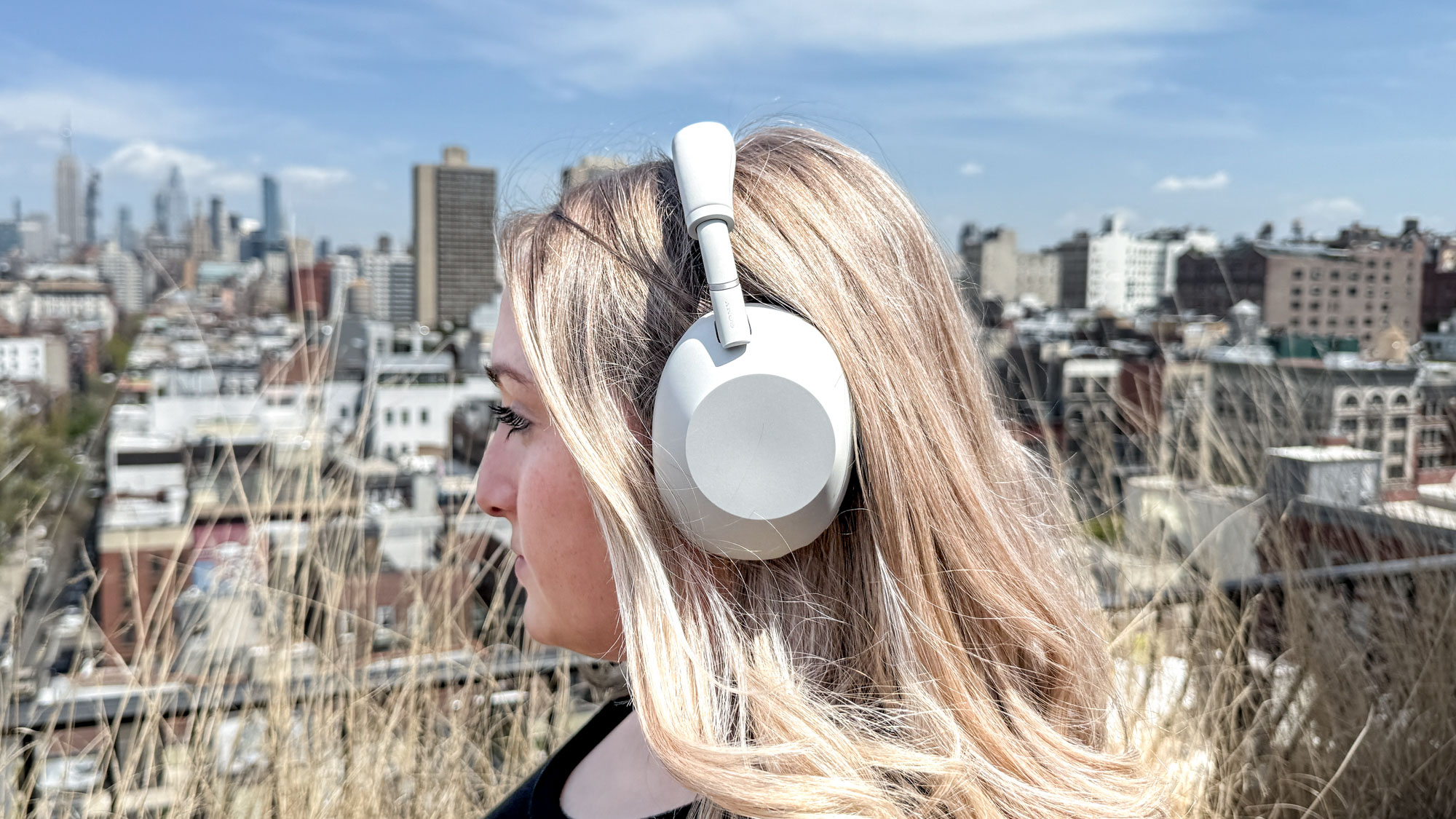 Vue latérale d'une femme portant un casque antibruit blanc Sony WH-1000XM6