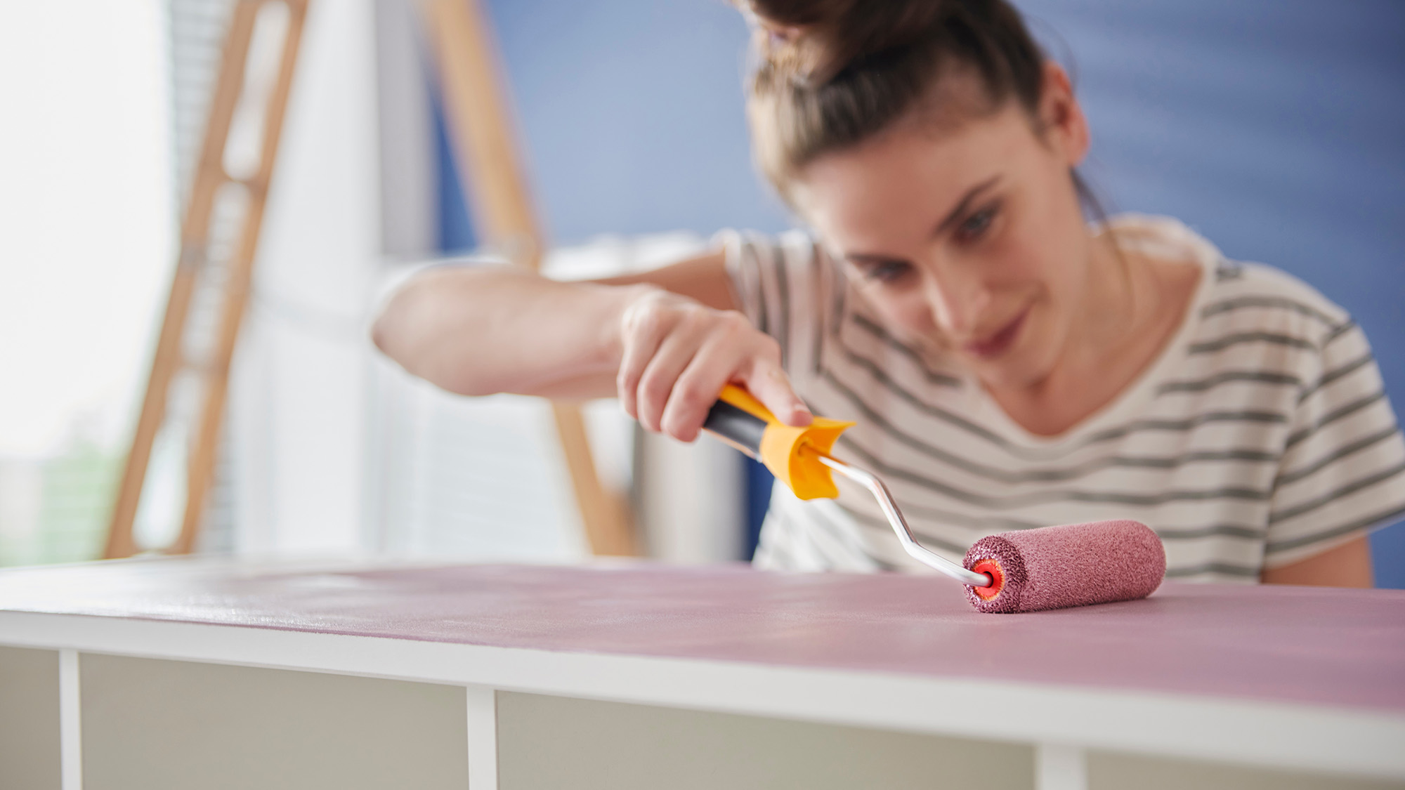 Étagère femme peignant avec un rouleau