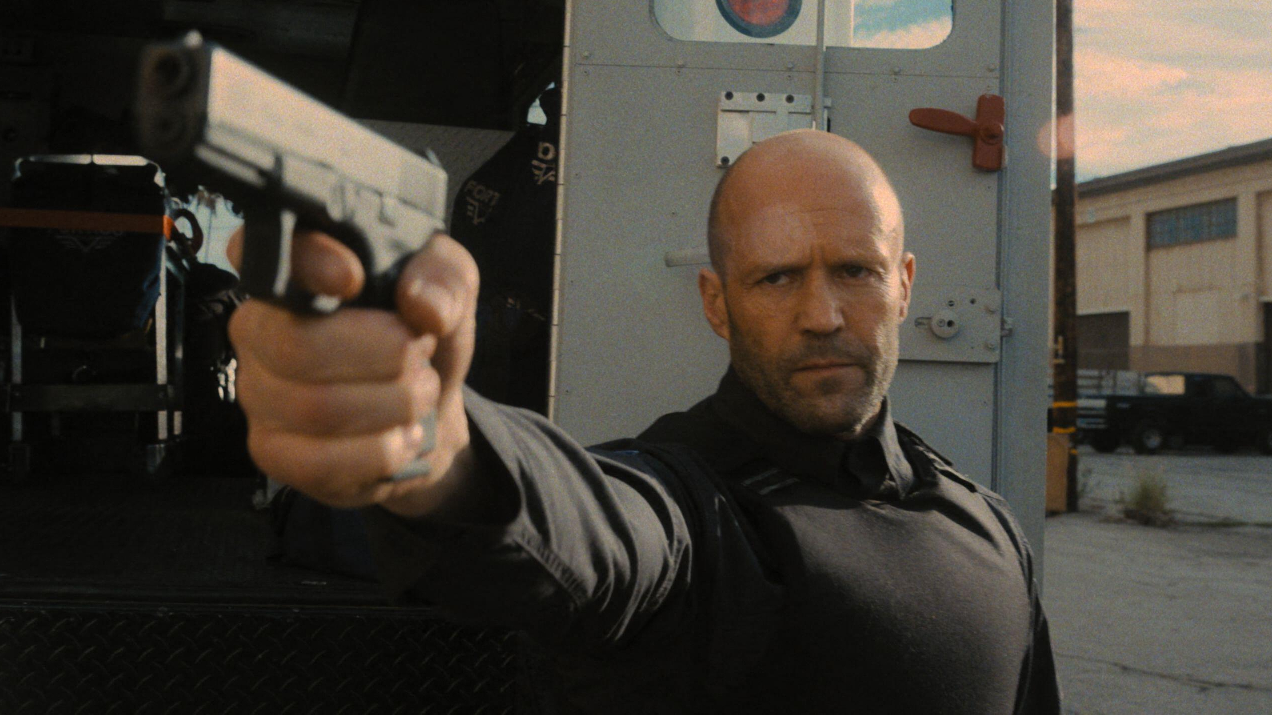 "H" (Jason Statham) prépare un pistolet dans une scène de