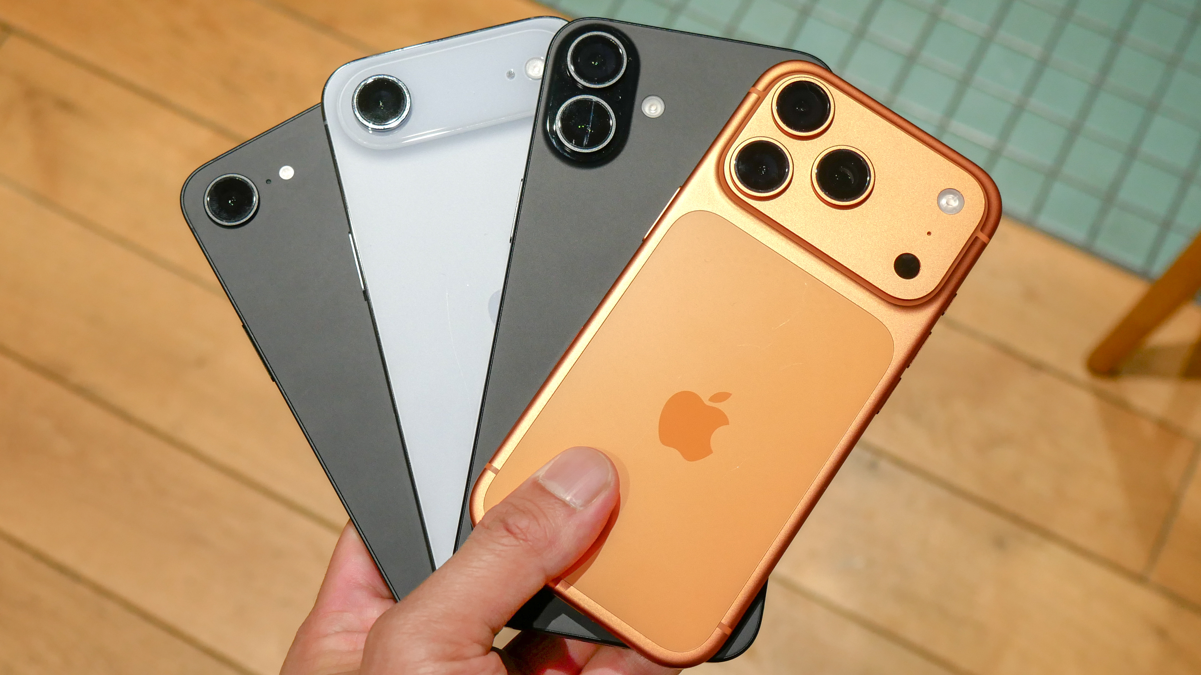 Un tas d'iPhones tenus dans la main.