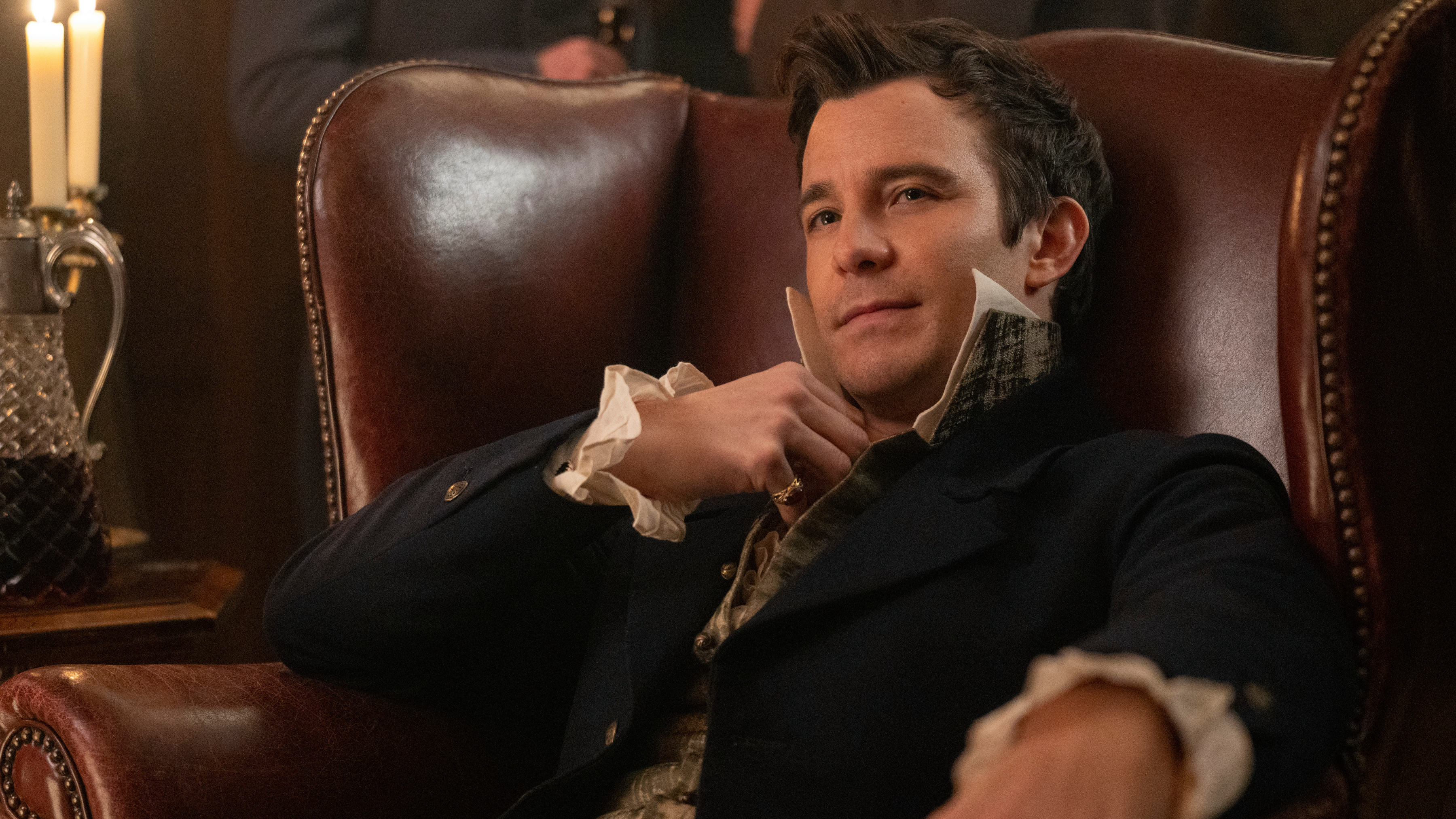 Luke Thompson s'incline sur une chaise dans le rôle de Benedict Bridgerton dans