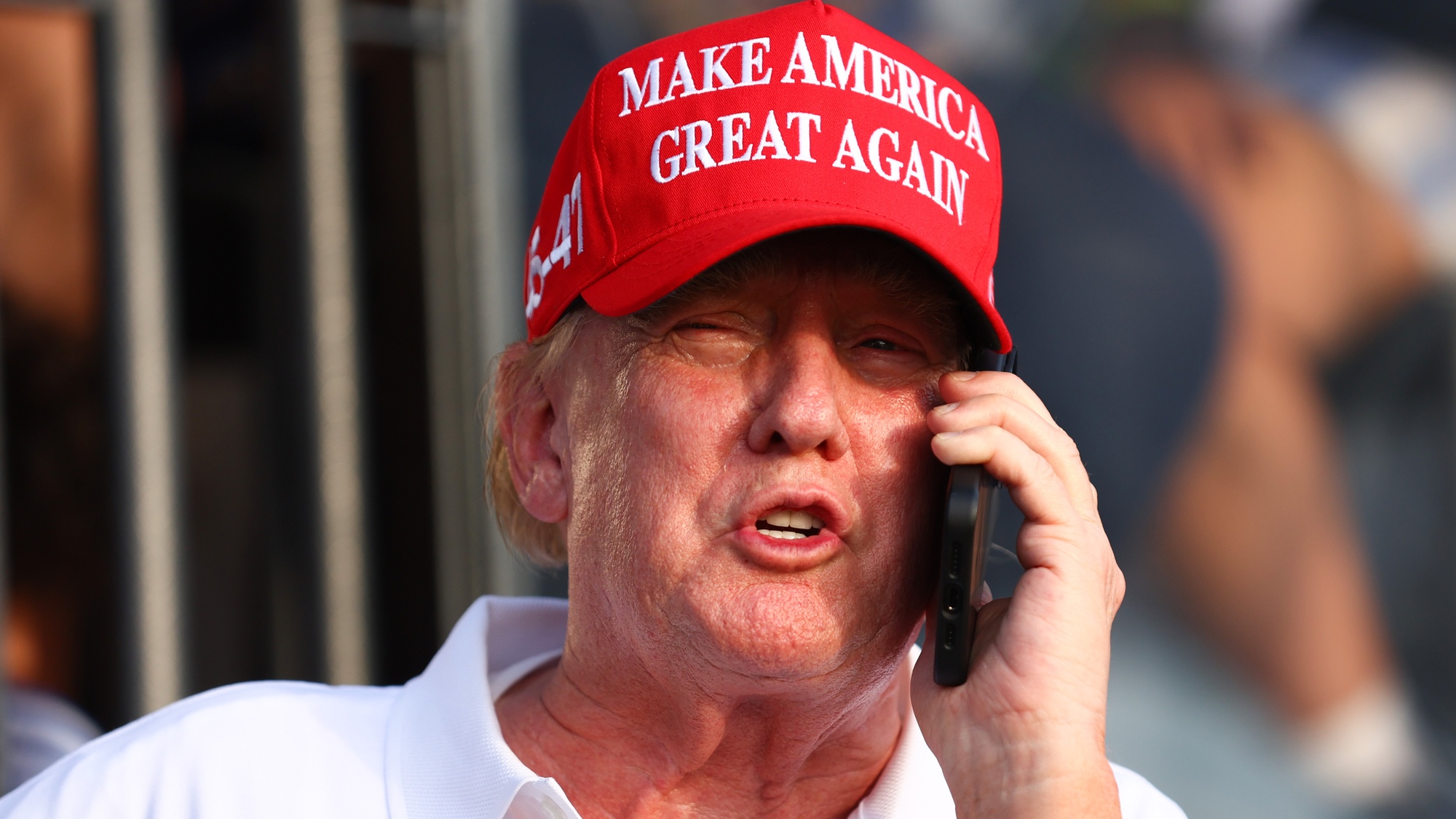 Donald Trump avec téléphone portant un chapeau rouge