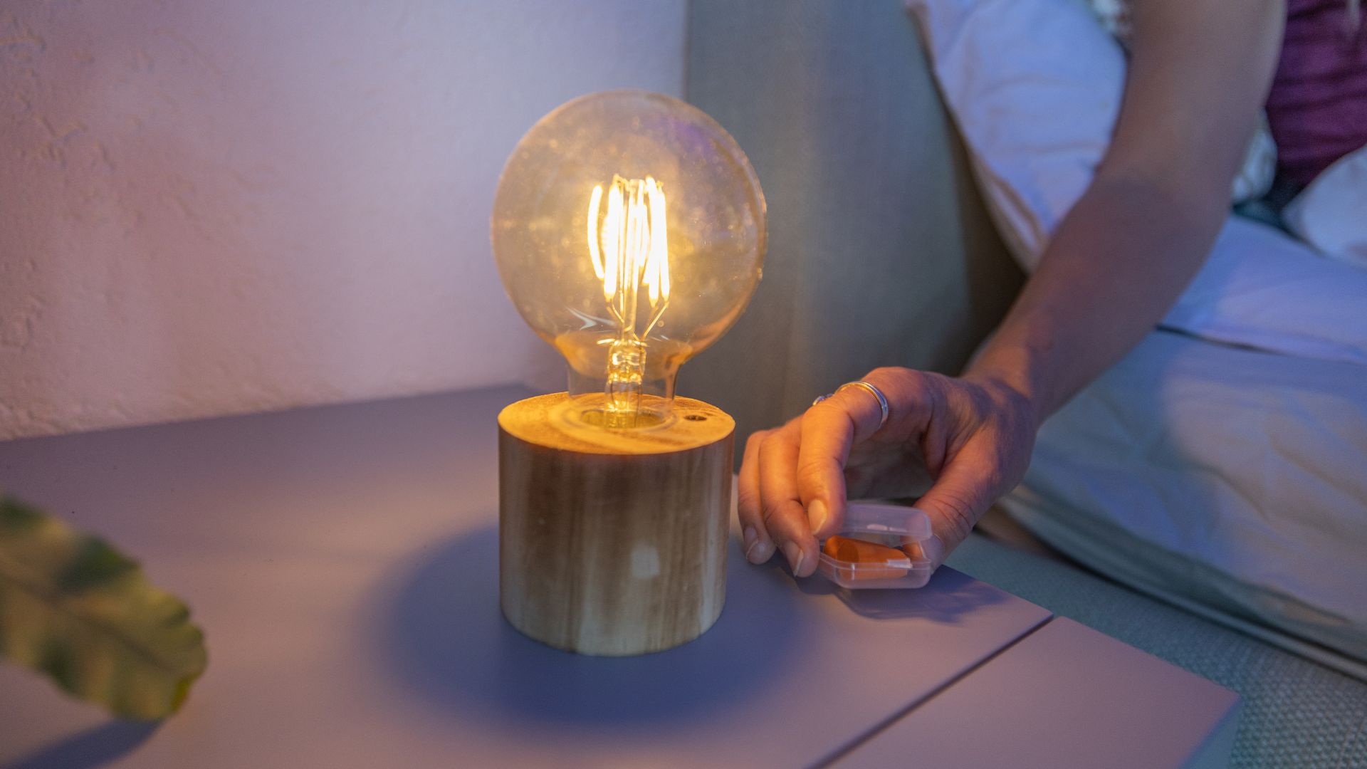 Une ampoule chaude et ambrée sur une table de nuit.