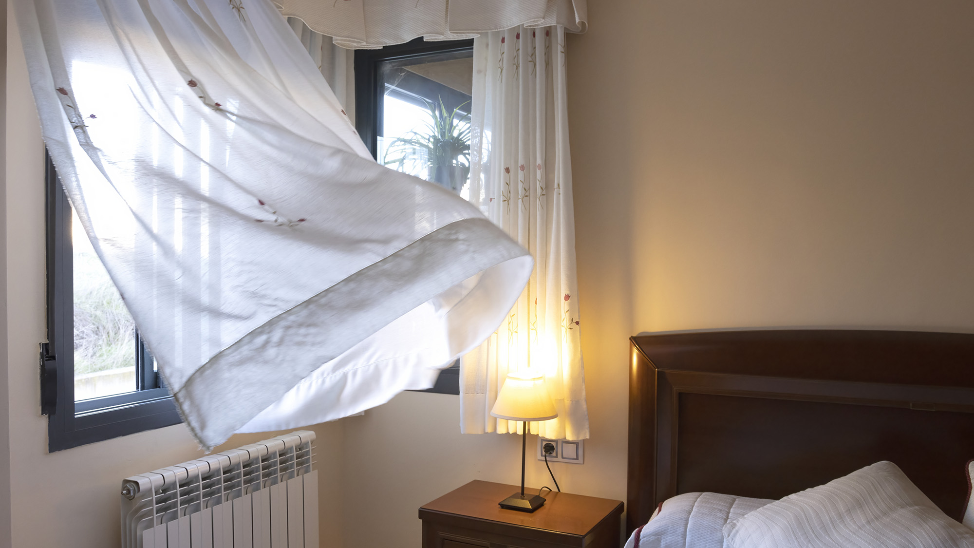 Fenêtre ouverte avec brise qui souffle dans la chambre