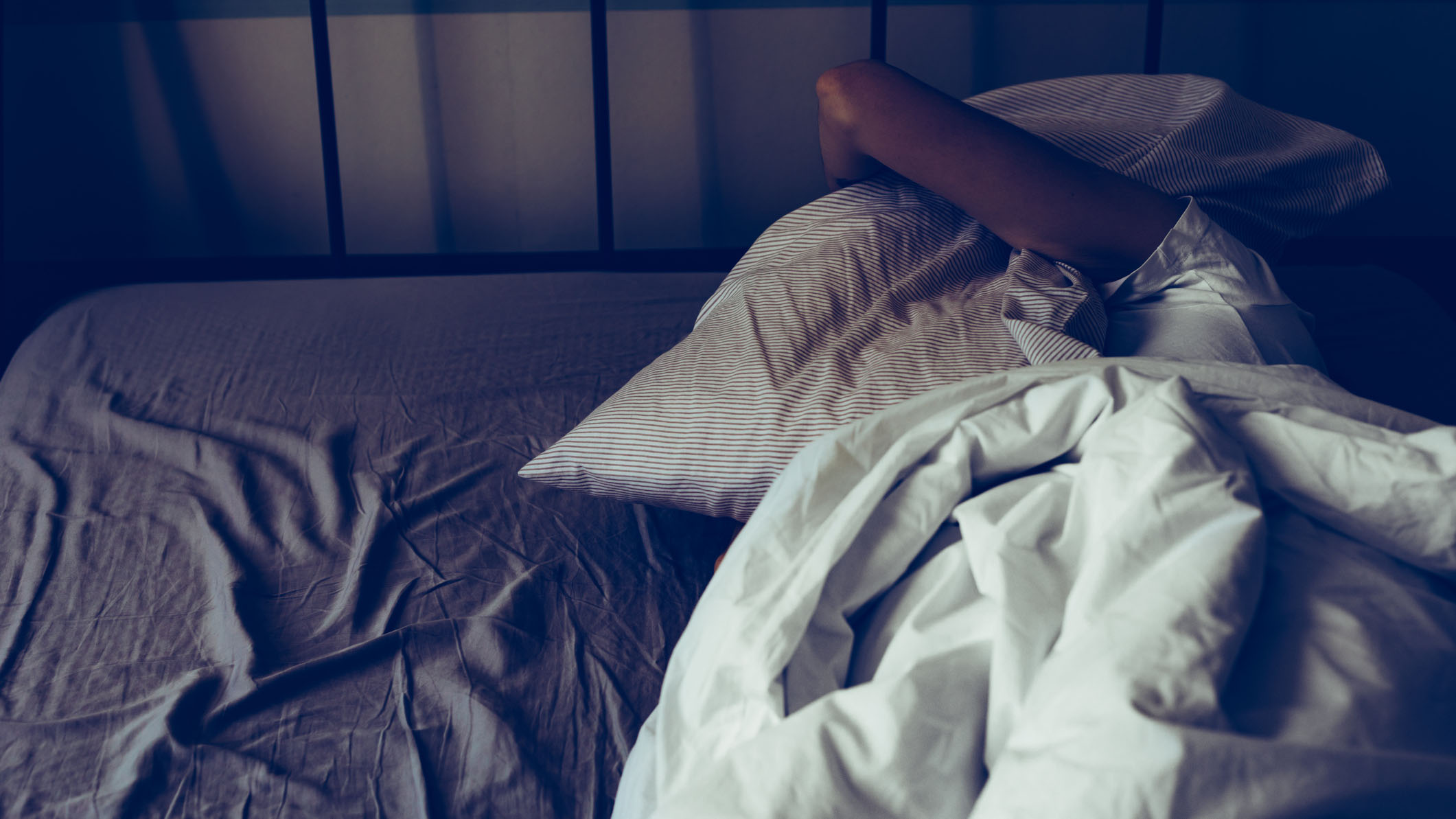 Une femme est allongée au lit, incapable de bien dormir