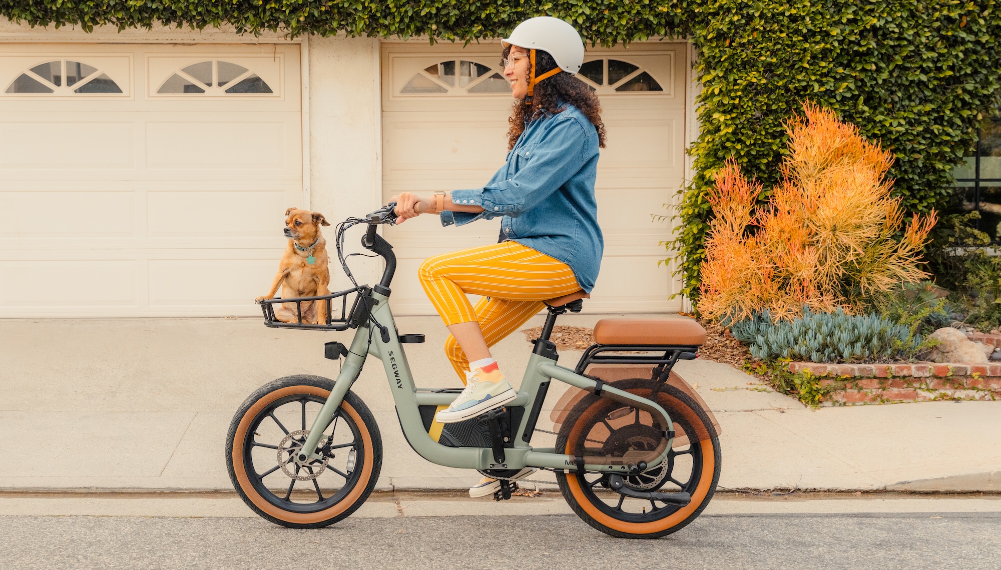 Femme chevauchant un vélo électrique Segway Muxi avec un chien