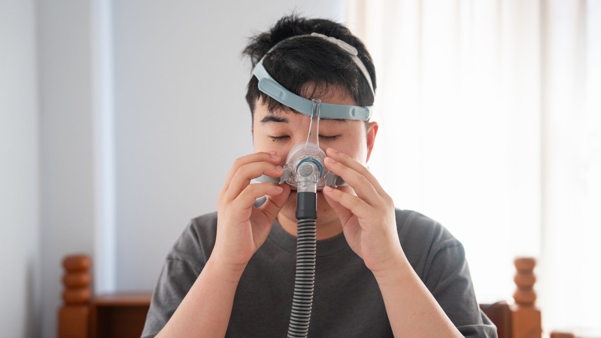 Un homme installe un masque CPAP pour soulager son apnée centrale du sommeil