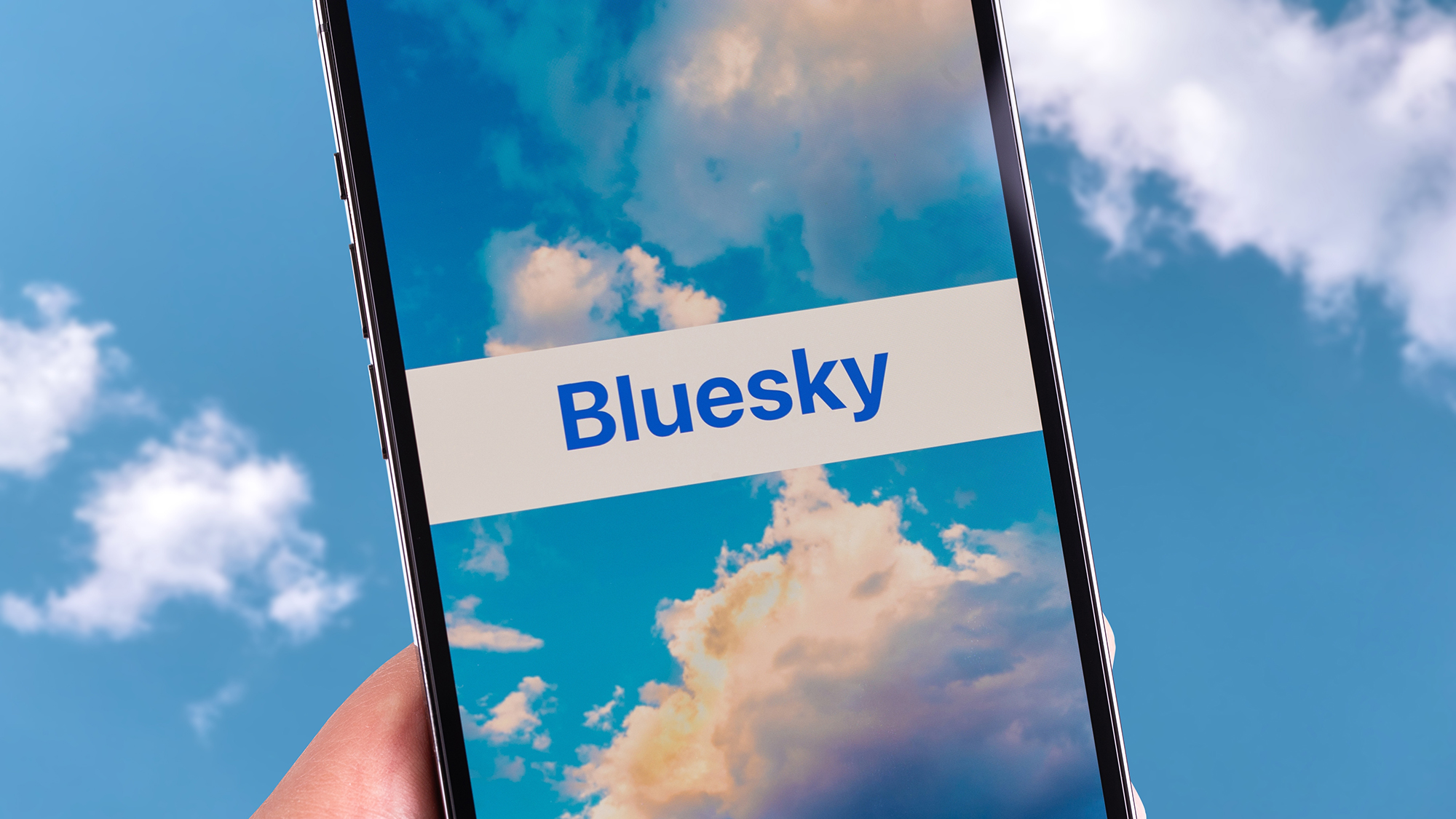 Le logo de l'application Bluesky entouré d'un ciel bleu sur l'écran d'inscription Bluesky.