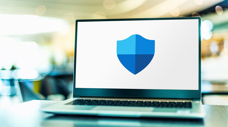 Le logo Microsoft Defender Antivirus, alias Windows Defender, sur l’écran d’un ordinateur portable posé sur une table ou un bureau.