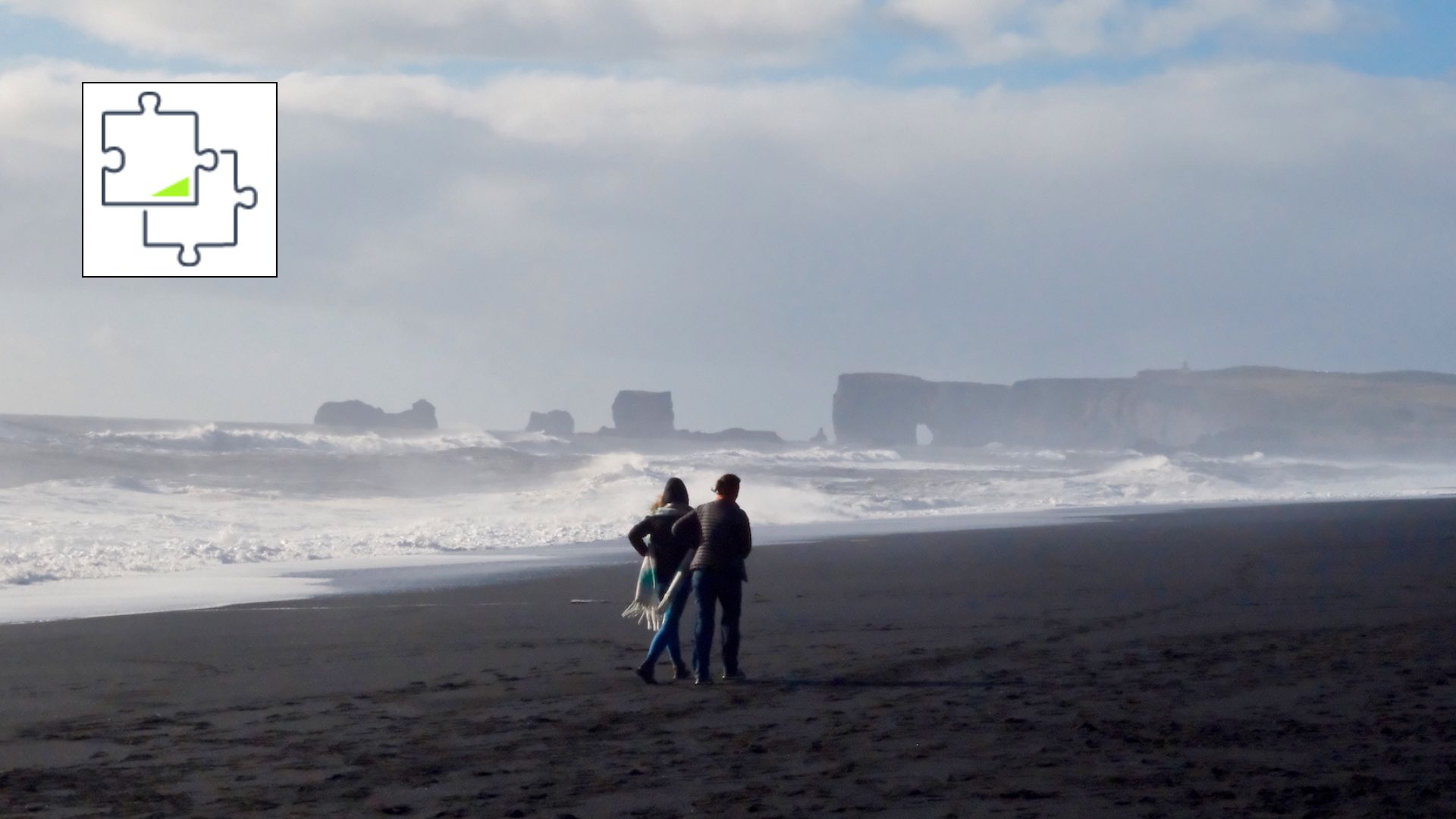 Une photo d’un couple sur une plage balayée par le vent en Islande