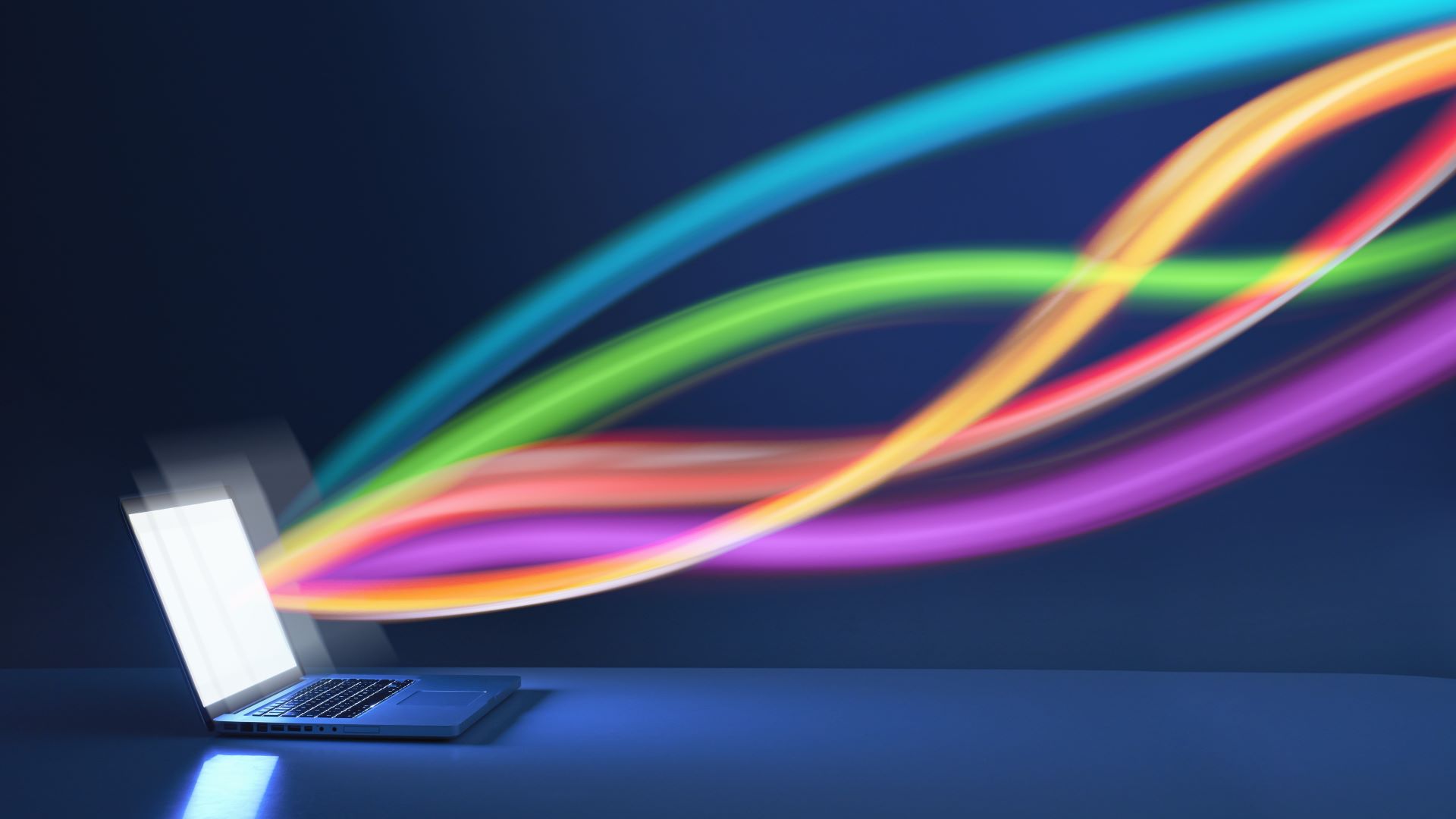 Une image conceptuelle de la vitesse d'Internet avec des rubans colorés sortant d'un ordinateur