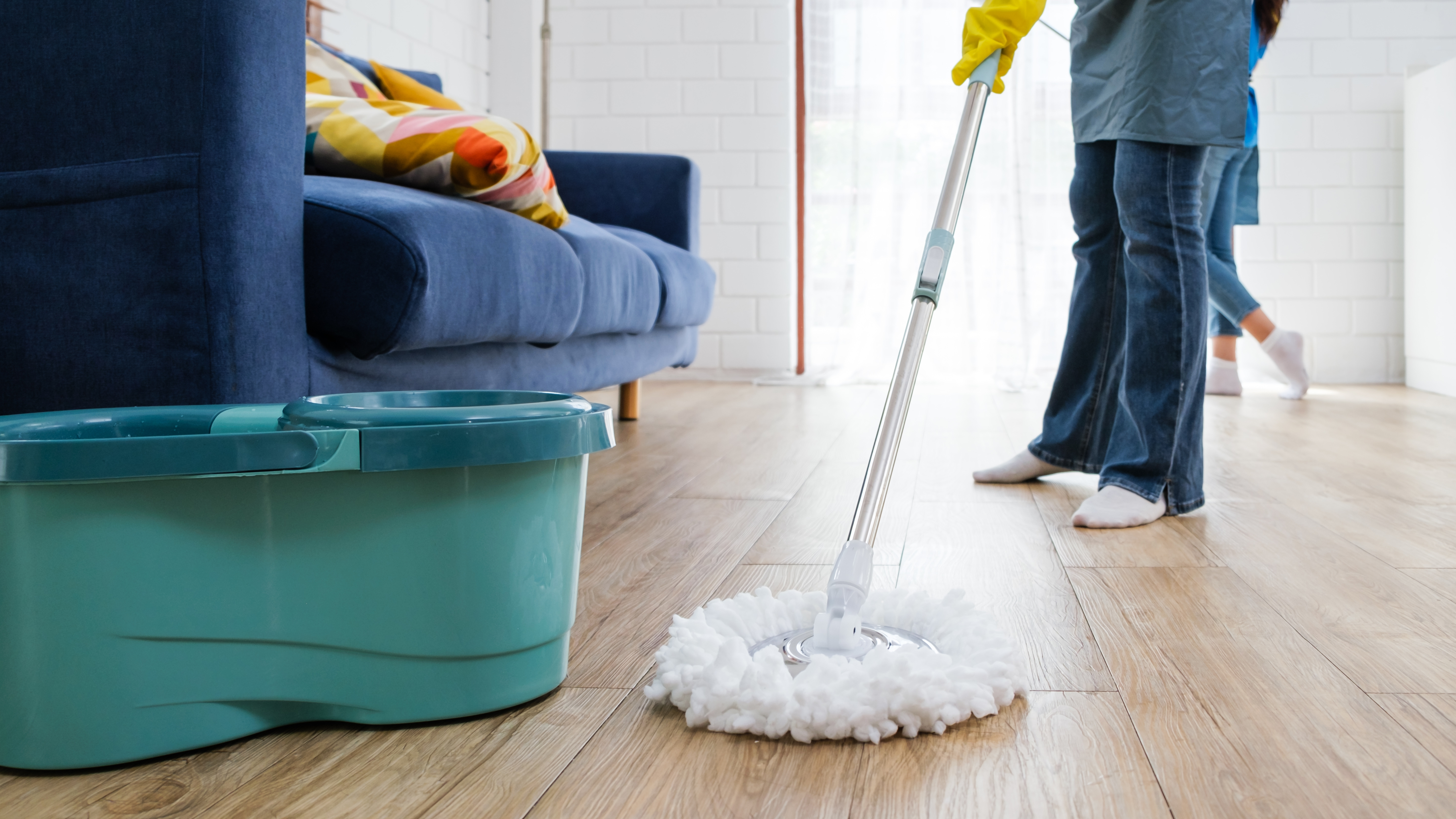 Femme nettoyant le parquet avec une vadrouille rotative