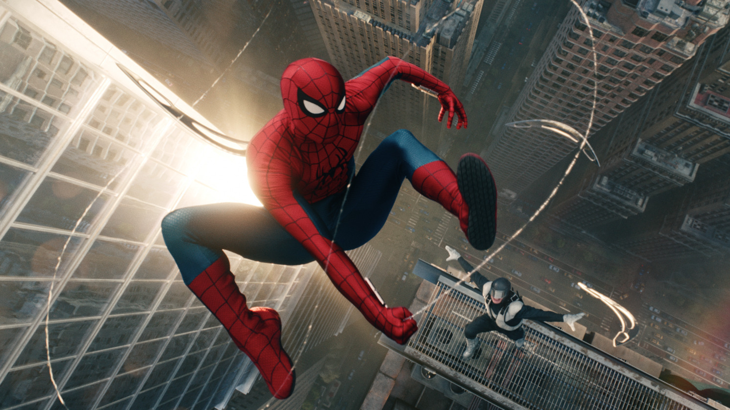 Spider-Man (Tom Holland) se balançant dans le ciel dans une image tirée de
