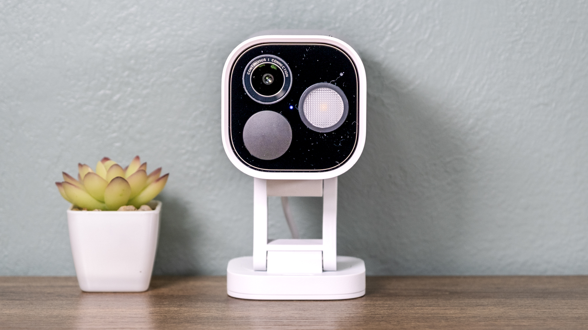 Aqara Camera Hub G5 Pro sur une étagère avec un petit cactus.