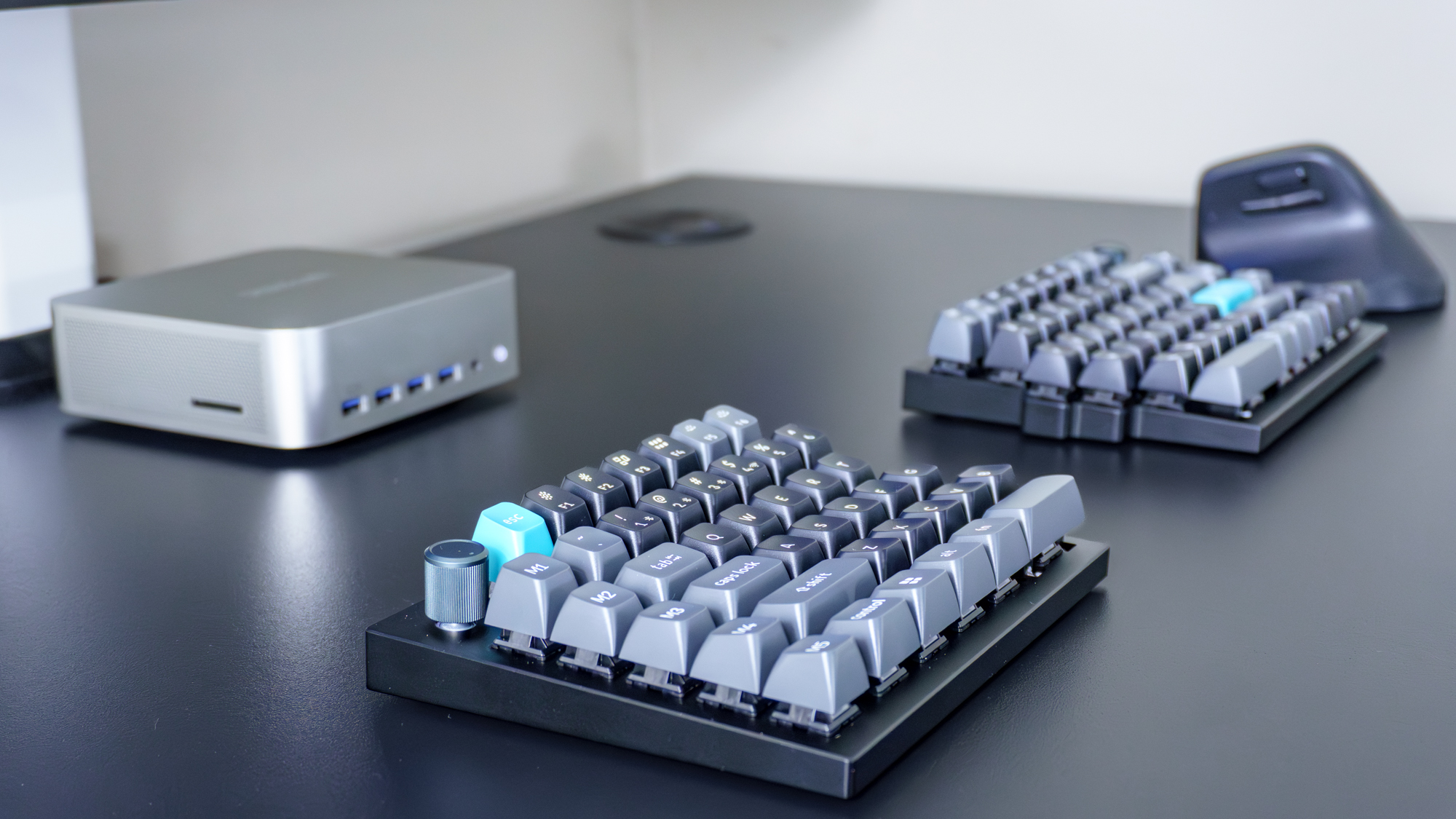 Le clavier mécanique divisé Keychron Q11 Ultra à côté d'une souris verticale et d'un mini PC sur un bureau