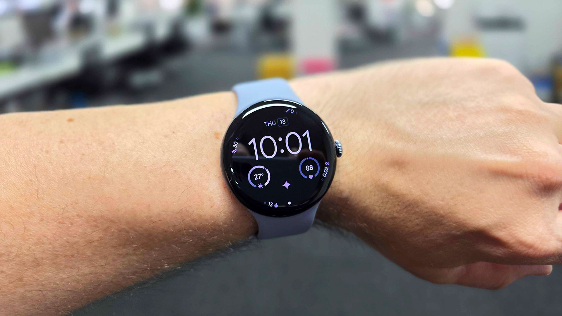 Pixel Watch 4 au poignet affichant l'heure, la météo et la fréquence cardiaque.