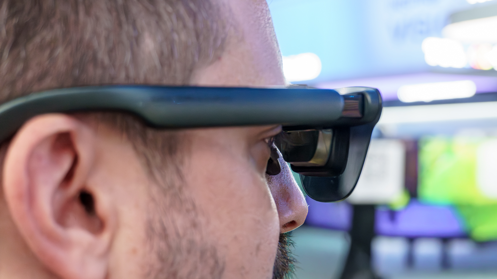 Gros plan d'une personne portant les lunettes RayNeo GT Max AR et regardant à travers leurs optiques à prisme